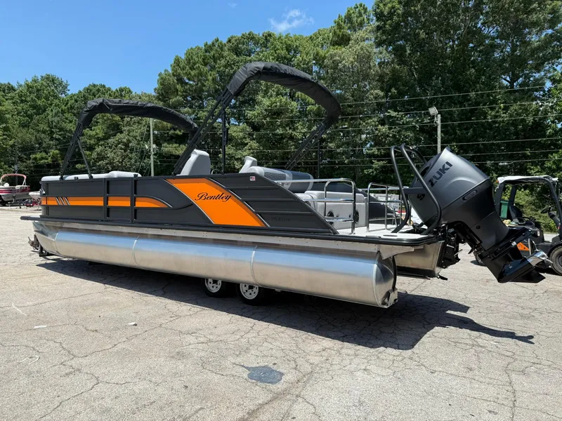 Slide: The Image of 2026 Bentley Pontoons Elite 253 Swingback with Suzuki outboard motor, parked outdoors. - 4