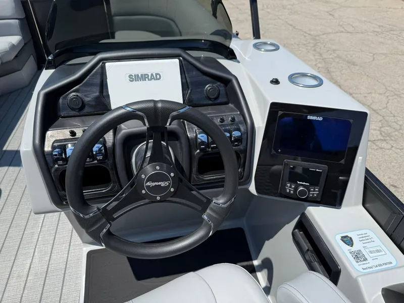 Slide: The Image of 2026 Bentley Pontoons Elite 253 Swingback dashboard with steering wheel and Simrad display. - 6