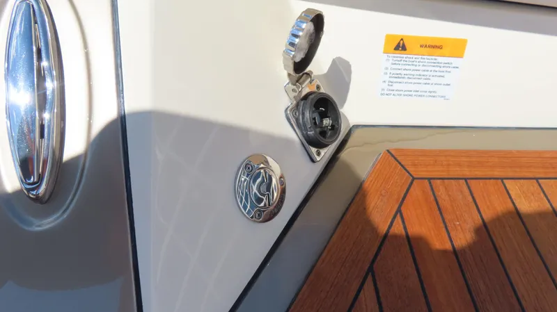 Slide: The Image of 2018 Chris-Craft Launch 34 boat detail with open power socket and warning label. - 10