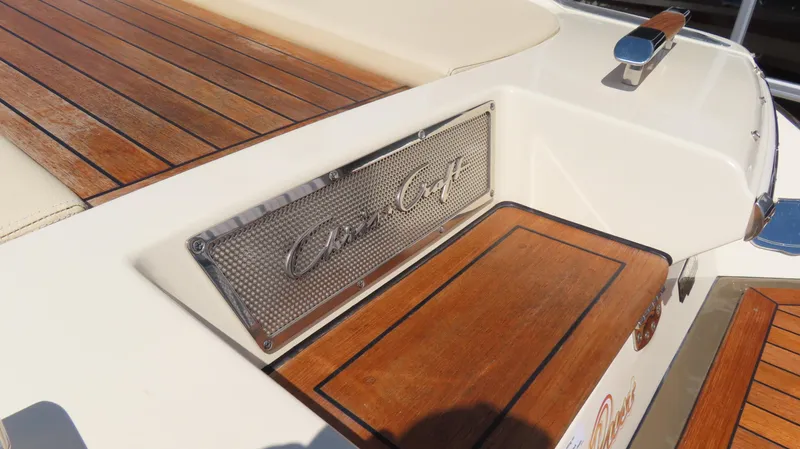 Slide: The Image of 2018 Chris-Craft Launch 34 boat with teak wood deck and branded metal plate. - 11