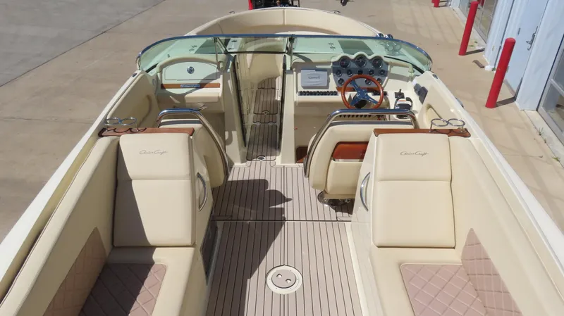 Slide: The Image of 2018 Chris-Craft Launch 34 boat interior with beige seating and wooden steering wheel. - 16