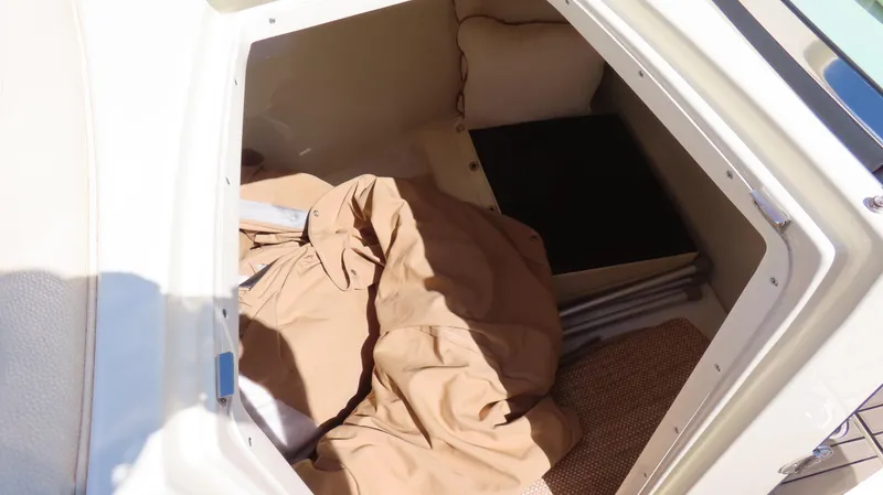 Slide: The Image of Storage compartment in 2018 Chris-Craft Launch 34 boat with beige cover and cushions. - 19