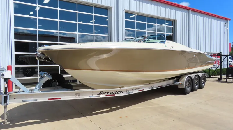 Slide: The Image of 2018 Chris-Craft Launch 34 boat on trailer, parked outside a modern building. - 2
