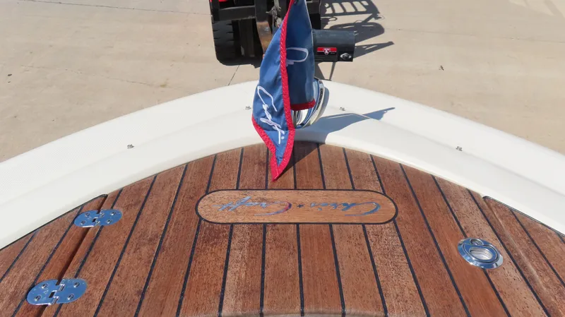 Slide: The Image of 2018 Chris-Craft Launch 34 boat deck with wooden finish and flag. - 24