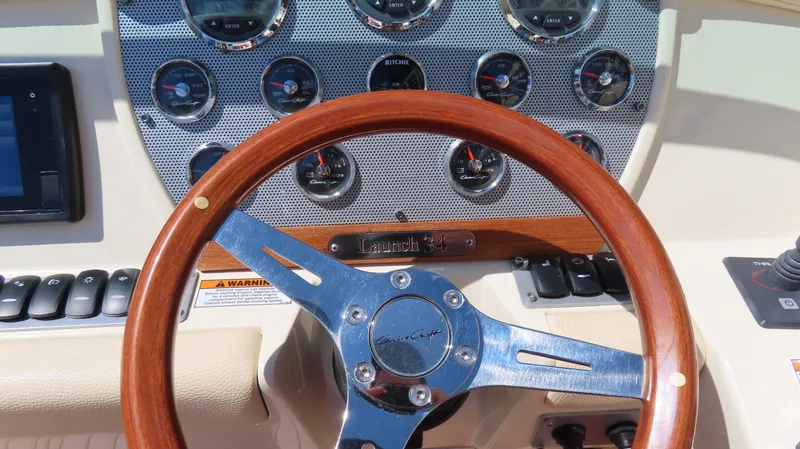 Slide: The Image of Dashboard of 2018 Chris-Craft Launch 34 with wooden steering wheel and gauges. - 31