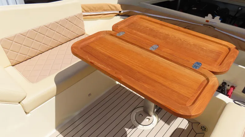 Slide: The Image of 2018 Chris-Craft Launch 34 interior with wooden table and beige seating. - 35