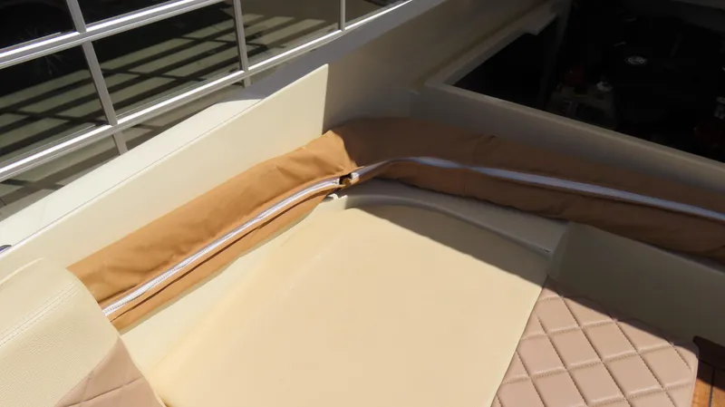Slide: The Image of 2018 Chris-Craft Launch 34 interior seating with beige upholstery and storage compartment. - 36