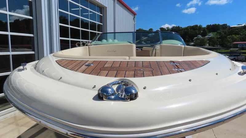 Slide: The Image of 2018 Chris-Craft Launch 34 boat with teak deck, docked near a modern building. - 4