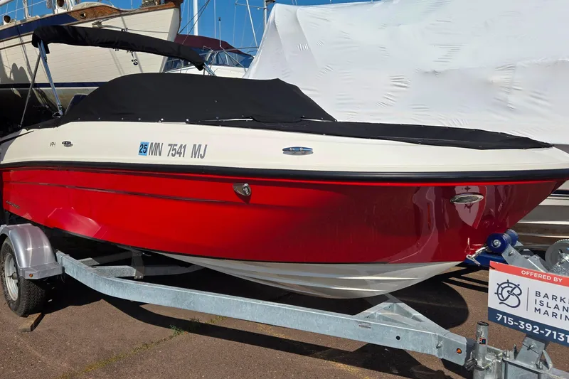 Slide: The Image of 2023 Bayliner VR4 Bowrider OB, red and white, on trailer, covered, at marina. - 3