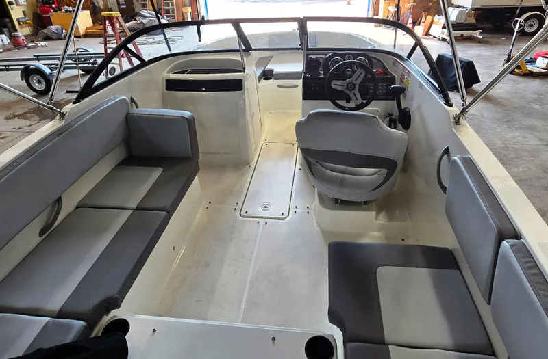 Slide: The Image of 2023 Bayliner VR4 Bowrider OB interior with gray seating and steering wheel in a garage setting. - 5