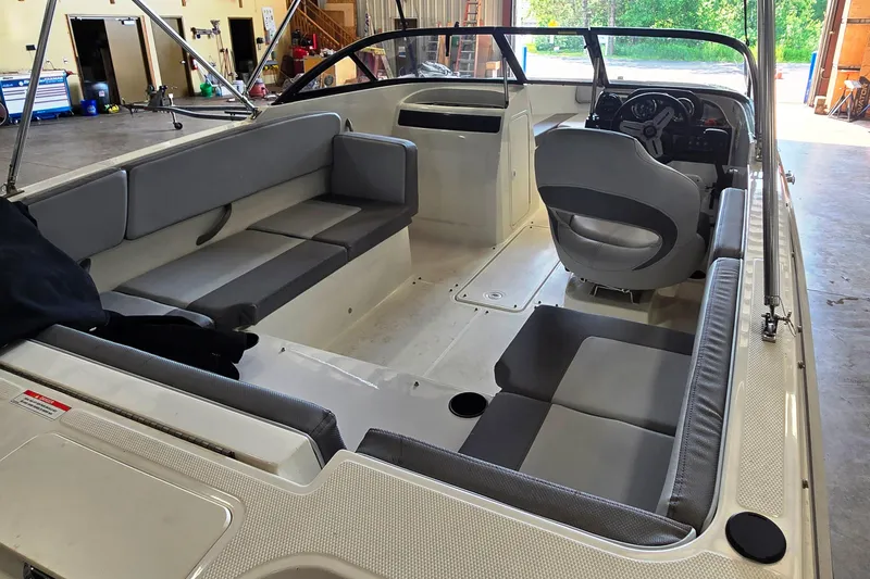 Slide: The Image of 2023 Bayliner VR4 Bowrider OB interior with gray seating and steering wheel in a garage setting. - 6