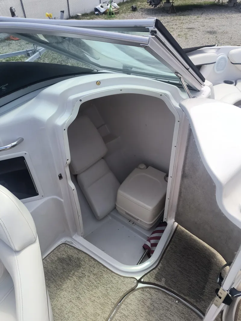 Slide: The Image of 2007 Four Winns 240 Horizon boat interior with open storage compartment and seating. - 11
