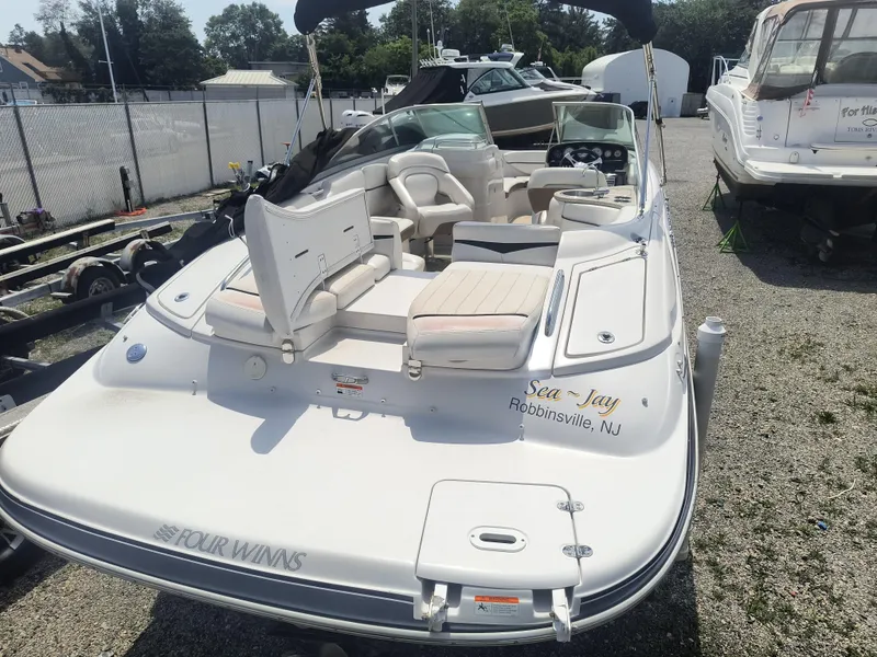 Slide: The Image of 2007 Four Winns 240 Horizon boat with open seating, parked in a marina. - 4
