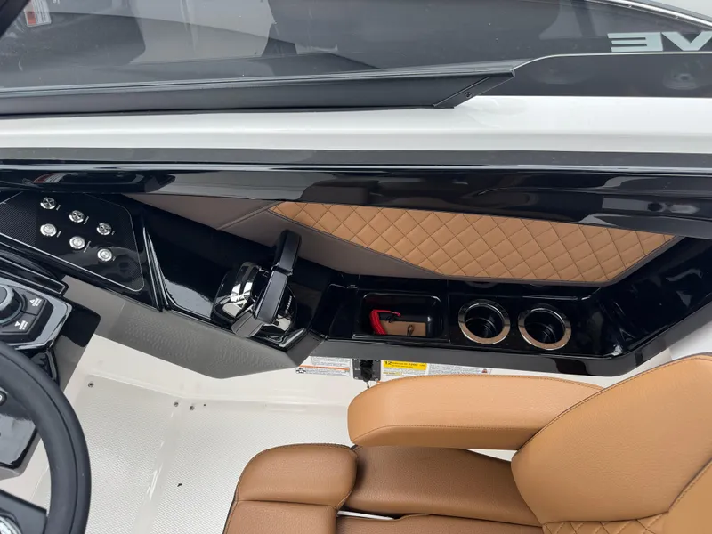 Slide: The Image of 2025 Yamaha Boats 252SD interior with tan seating, control panel, and cup holders. - 24