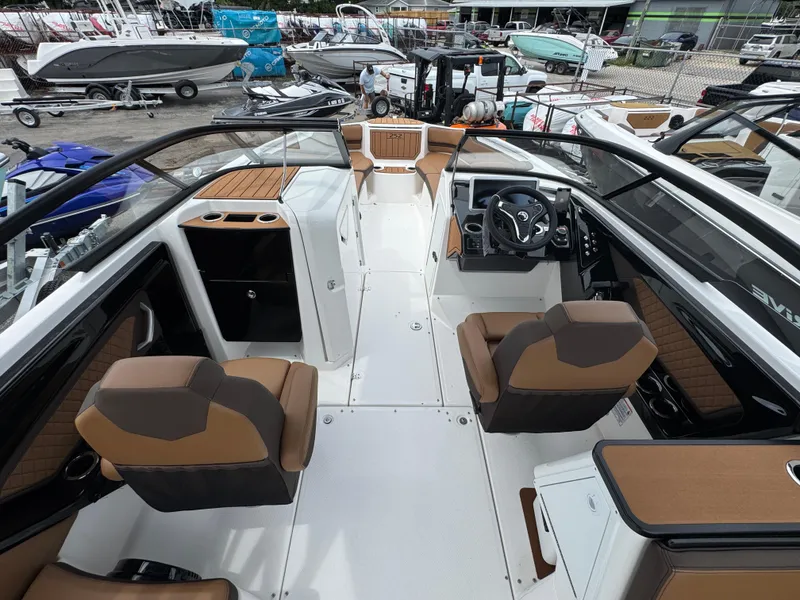 Slide: The Image of 2025 Yamaha Boats 252SD interior with modern seating and steering, docked among other boats. - 8