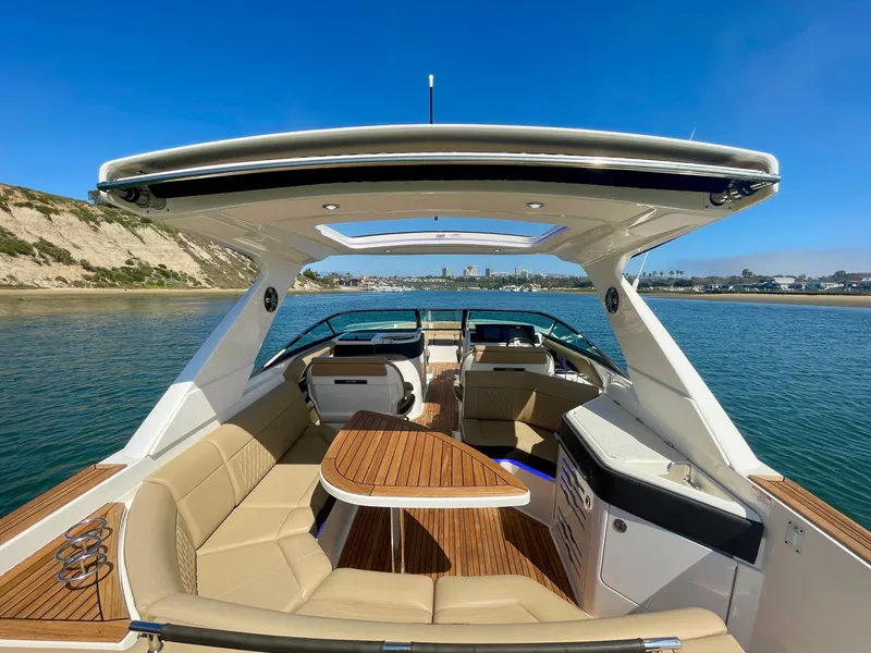 Slide: The Image of 2019 Sea Ray SLX 310 boat with spacious seating and elegant design on calm water. - 10