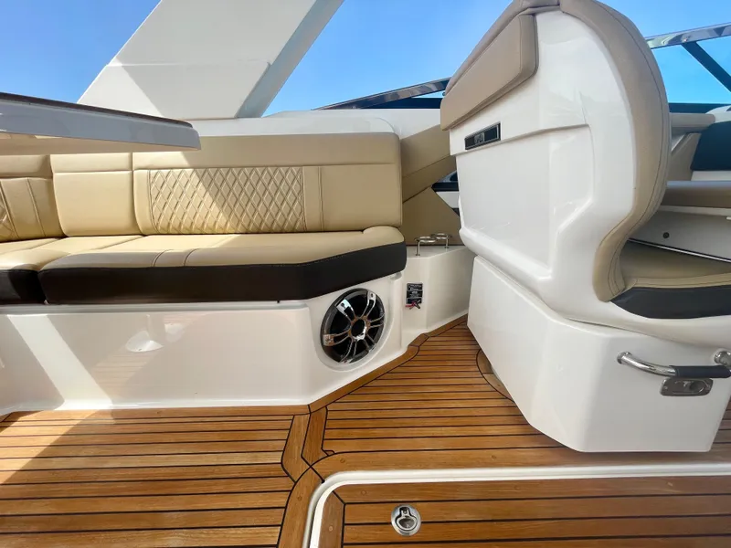 Slide: The Image of 2019 Sea Ray SLX 310 interior with beige seating and teak flooring. - 20