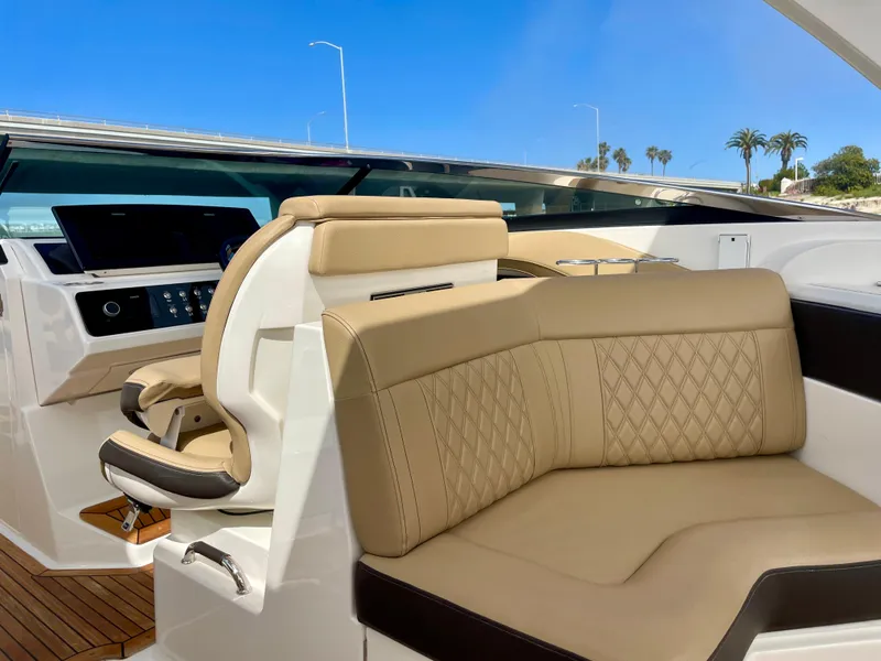 Slide: The Image of 2019 Sea Ray SLX 310 boat interior with beige leather seating and modern dashboard. - 21