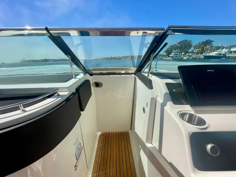 Slide: The Image of 2019 Sea Ray SLX 310 boat interior with wooden flooring and clear view of the water. - 27