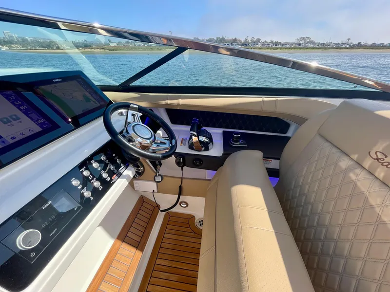 Slide: The Image of 2019 Sea Ray SLX 310 boat interior with steering wheel and dashboard, overlooking water. - 33