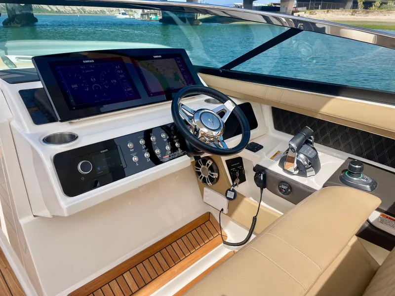 Slide: The Image of 2019 Sea Ray SLX 310 helm with modern controls and dual displays on a sunny day. - 36