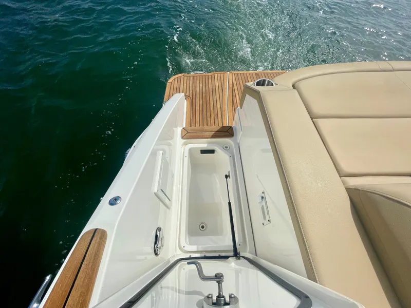 Slide: The Image of 2019 Sea Ray SLX 310 boat with teak deck and beige seating on water. - 45