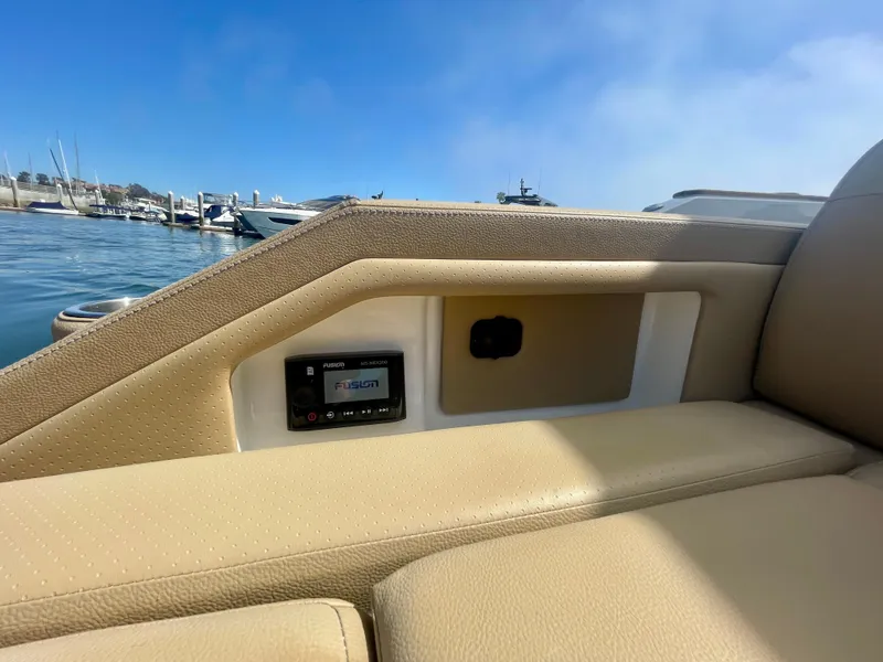 Slide: The Image of 2019 Sea Ray SLX 310 boat interior with beige seating and control panel, docked at marina. - 47