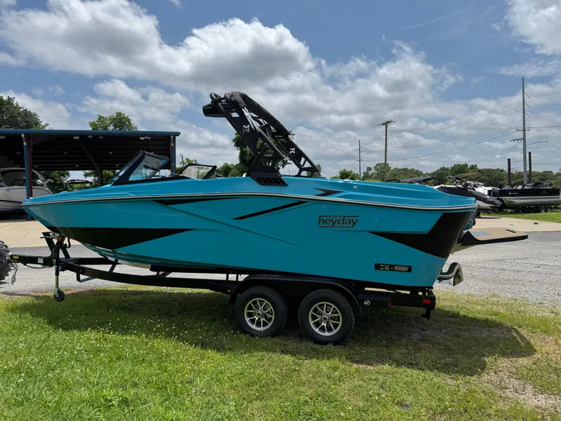 Slide: The Image of 2025 Heyday H22 boat in vibrant blue on a trailer, parked outdoors. - 3