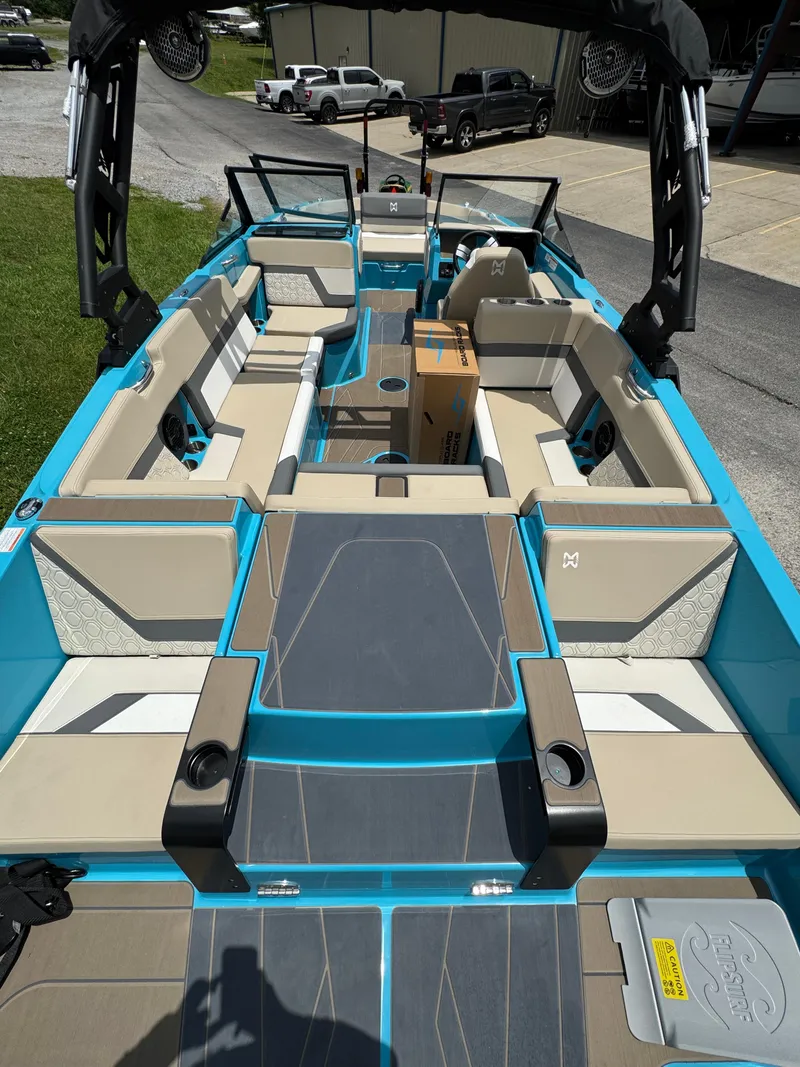 Slide: The Image of 2025 Heyday H22 boat interior with beige seating and blue accents, parked outdoors. - 5