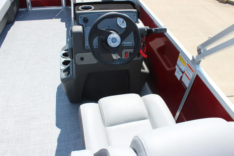 Slide: The Image of 2026 Sun Tracker Party Barge 16 DLX steering console with comfortable seating and cup holders. - 14