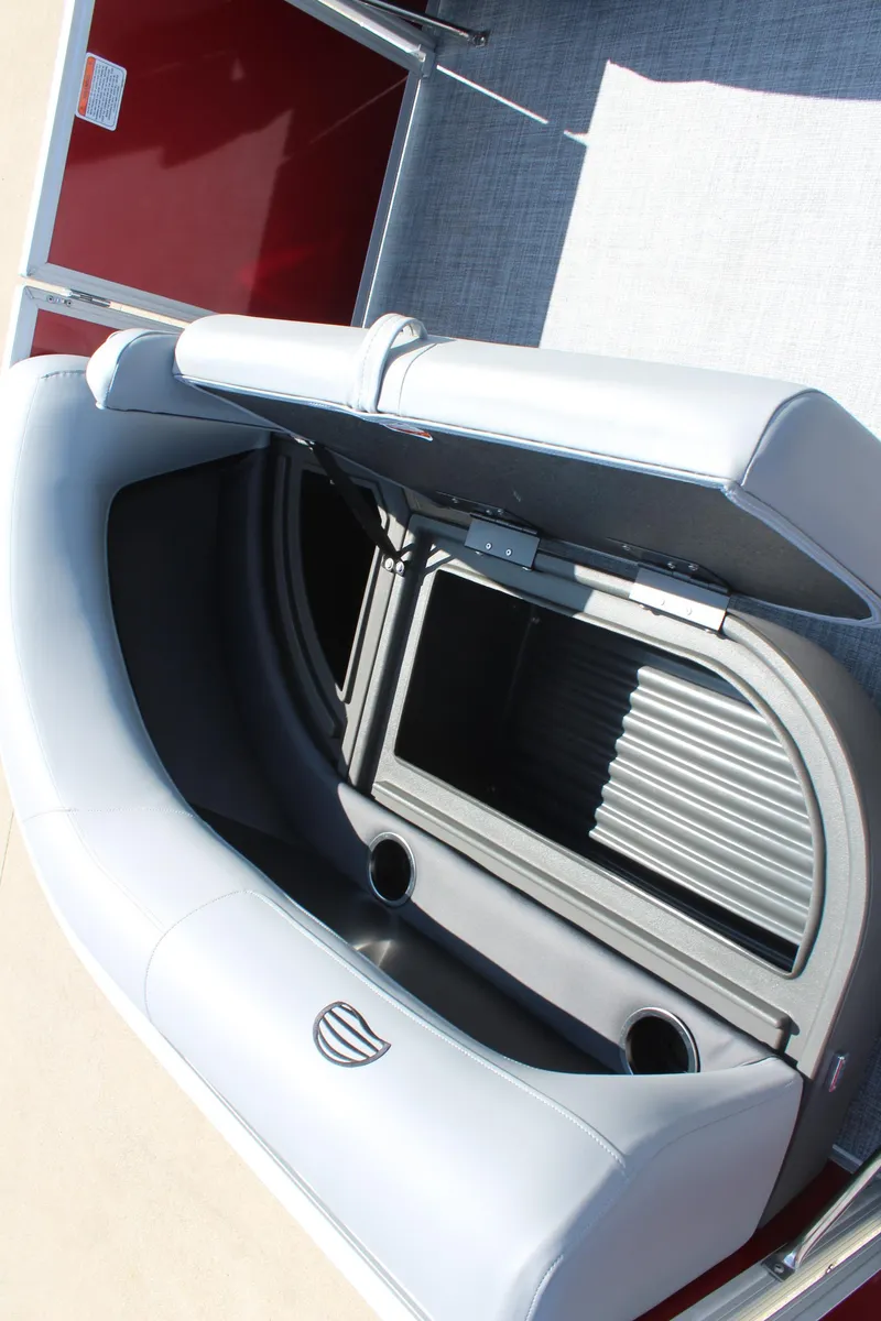 Slide: The Image of 2026 Sun Tracker Party Barge 16 DLX seat storage with cup holders and open compartment. - 18