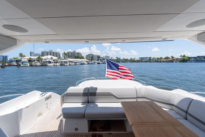 Slide: The Image of Sunseeker Predator 60 yacht, 2022 model, with American flag, docked in a marina. - 29