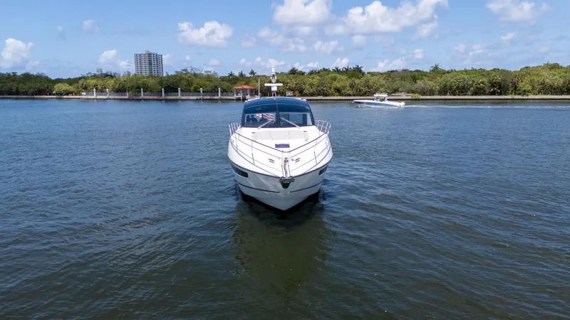 Slide: The Image of 2022 Sunseeker Predator 60 yacht on calm water, clear sky, and distant shoreline. - 3