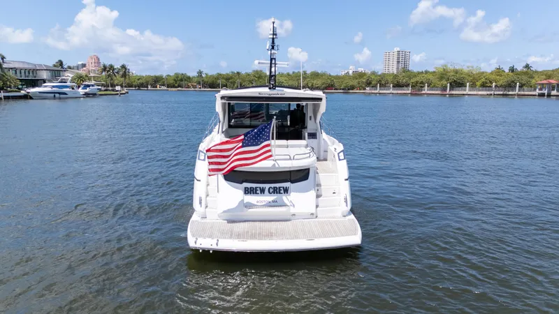Slide: The Image of Sunseeker Predator 60 yacht, 2022 model, with American flag, on a sunny waterway. - 5