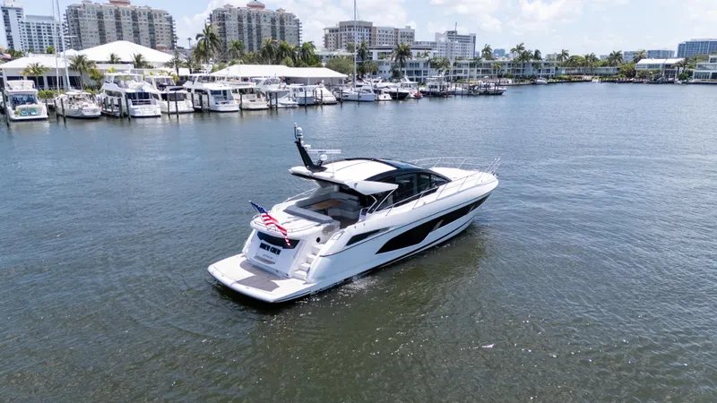 Slide: The Image of 2022 Sunseeker Predator 60 yacht cruising in a marina with cityscape background. - 8