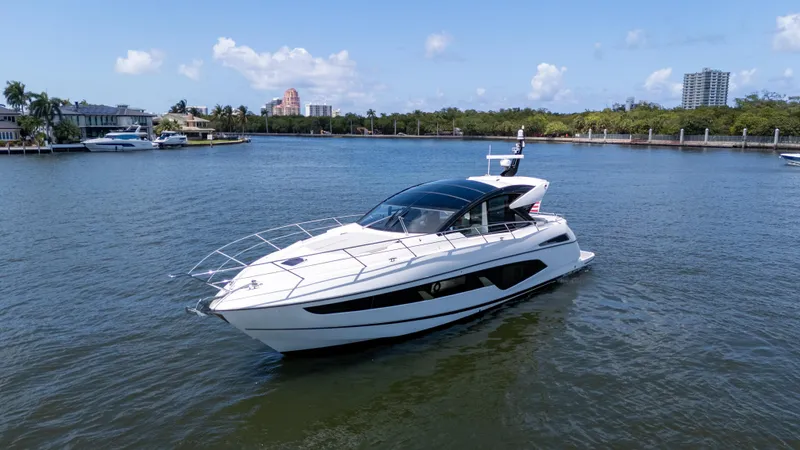 Slide: The Image of 2022 Sunseeker Predator 60 yacht cruising on a sunny day in a scenic waterway. - 9