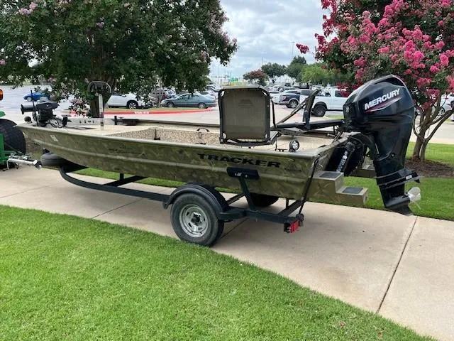 Slide: The Image of 2023 Tracker 1654SPT boat on trailer with Mercury outboard motor, parked on grass. - 3