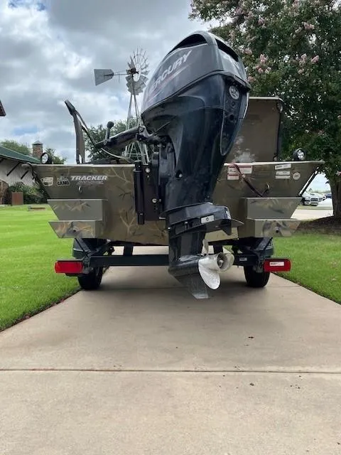 Slide: The Image of 2023 Tracker 1654SPT boat on trailer with Mercury outboard motor, parked on driveway. - 4