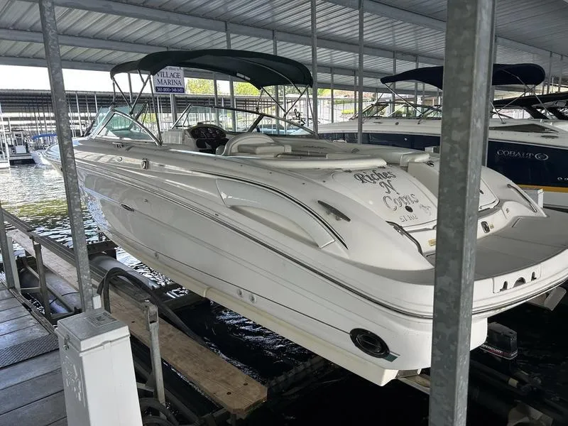 Slide: The Image of 2002 Sea Ray 290 boat docked in a marina under a covered structure. - 11