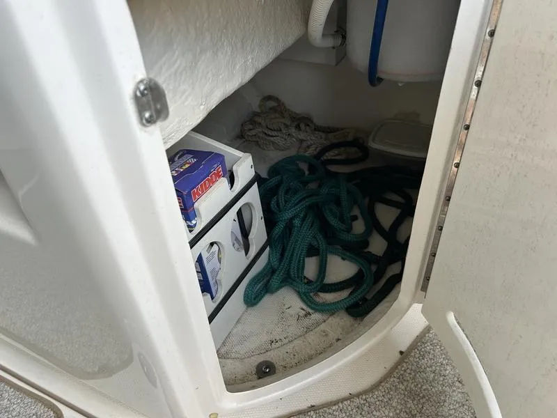 Slide: The Image of Storage compartment on a 2002 Sea Ray 290 boat with ropes and supplies. - 15