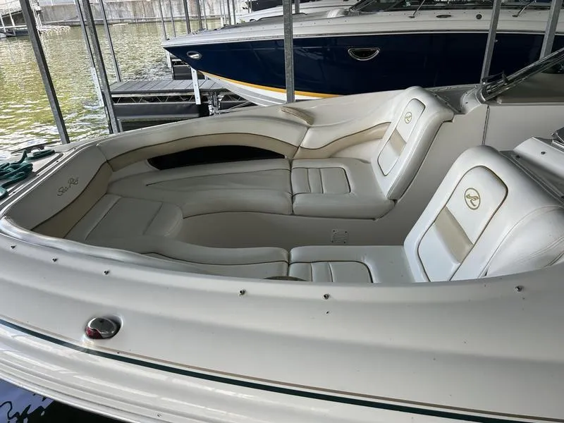 Slide: The Image of 2002 Sea Ray 290 boat interior with white leather seating in a marina. - 9