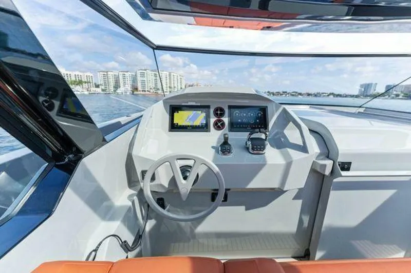 Slide: The Image of Helm of 2021 Vanquish VQ58 yacht with modern controls and waterfront view. - 10