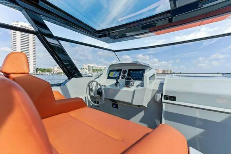 Slide: The Image of Interior of 2021 Vanquish VQ58 yacht with orange seating and modern dashboard. - 11