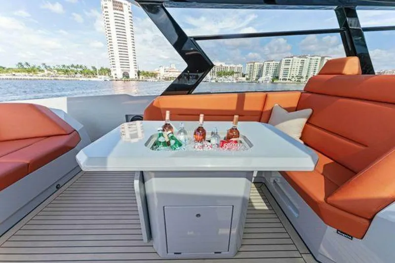 Slide: The Image of Luxurious 2021 Vanquish VQ58 yacht interior with orange seating and drinks on the table. - 12