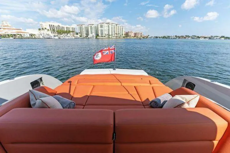 Slide: The Image of Luxury Vanquish VQ58 yacht with orange seating, scenic waterfront view, and red flag. - 17