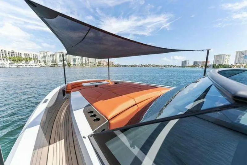 Slide: The Image of Luxury Vanquish VQ58 yacht with sunshade, docked near waterfront buildings, 2021 model. - 28