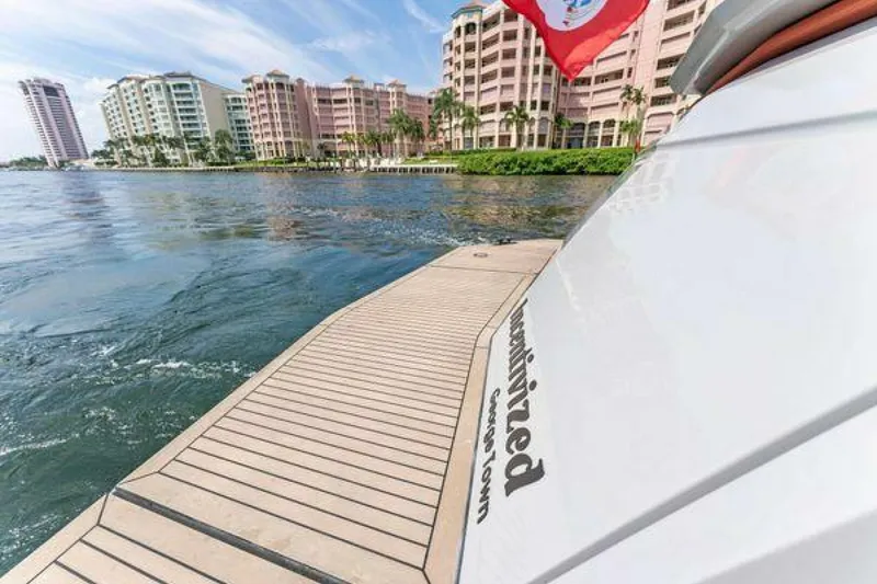 Slide: The Image of Vanquish VQ58 yacht near waterfront buildings, 2021 model, with a flag waving. - 32