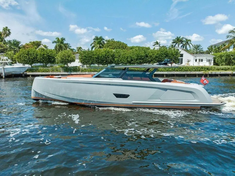 Slide: The Image of 2021 Vanquish VQ58 yacht cruising on a sunny day, surrounded by lush greenery. - 4