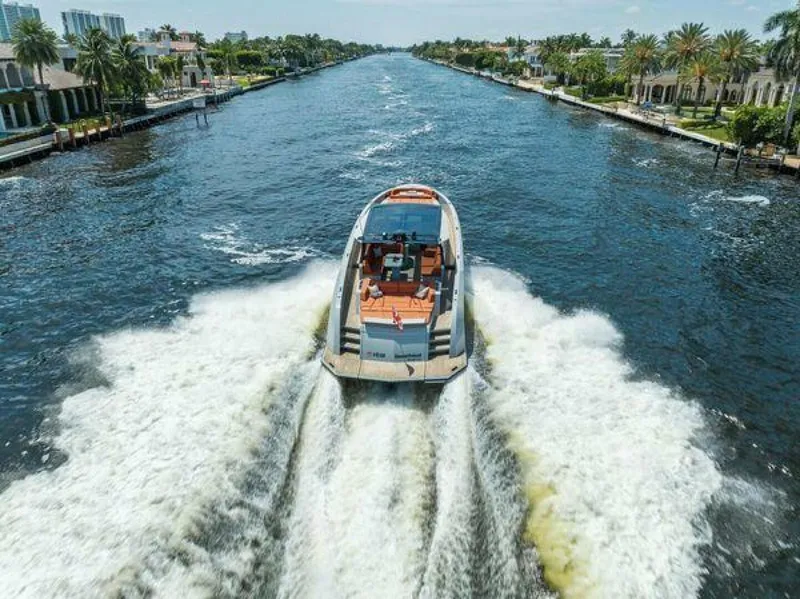 Slide: The Image of 2021 Vanquish VQ58 yacht cruising on a scenic waterway, surrounded by luxury homes and palm trees. - 42