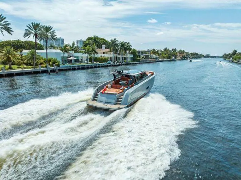 Slide: The Image of Luxury Vanquish VQ58 yacht cruising on a scenic waterway, surrounded by palm trees. - 43